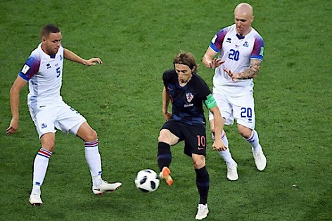 Mittefeld-Fußballer Luka Modrić (Kroatien) gegen Verteidiger Sverrir Ingason von Island im Spiel der Gruppe D in der russischen Rostov-Arena, 26.6.2018